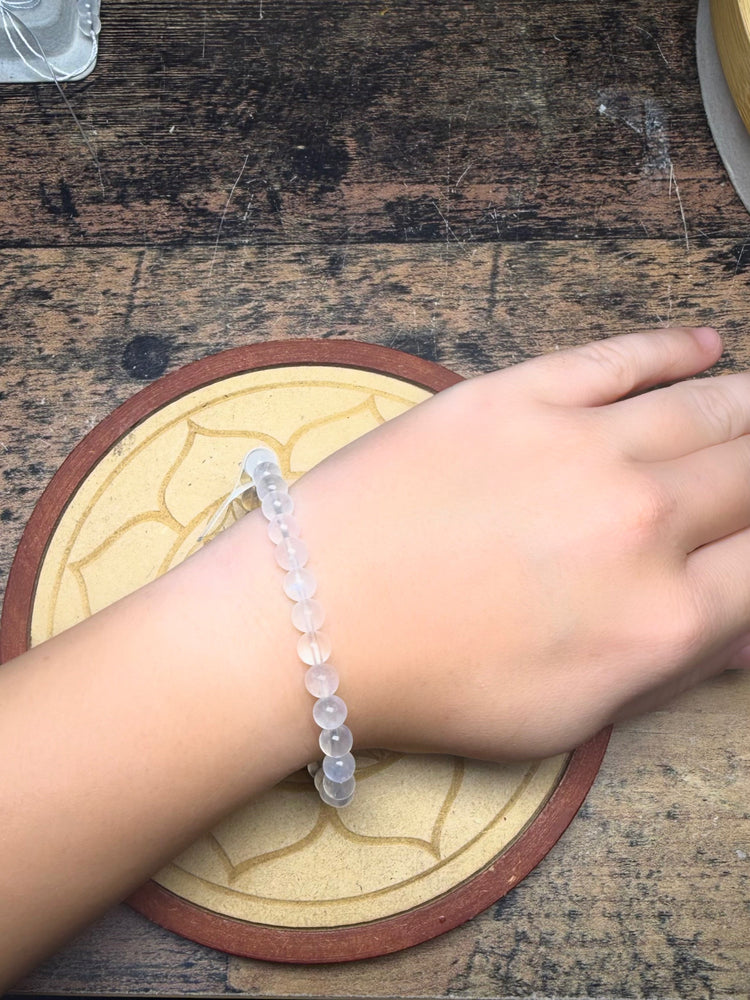 Bracelet en pierre de lune porté au poignet, pierre traditionnellement associée à la maternité