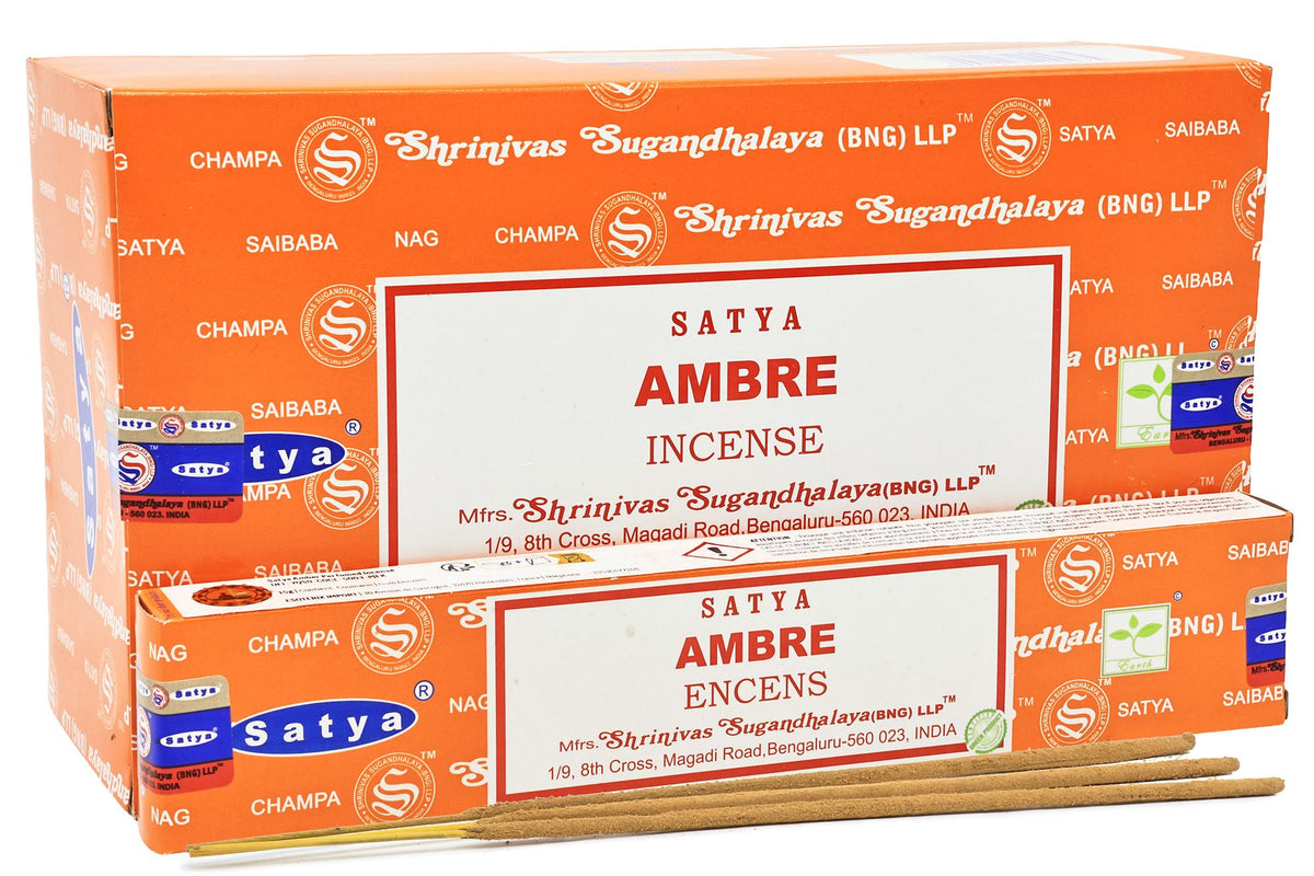 Boîte orange d'encens Satya Ambre avec un paquet ouvert et trois bâtonnets devant