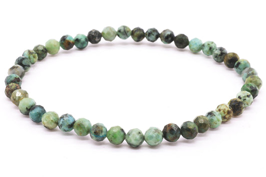 Bracelet élastique de perles facettées de Turquoise Africaine aux nuances vertes et bleutées sur fond blanc