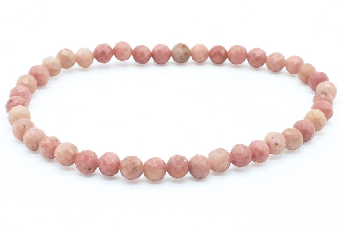 Bracelet de perles rondes facettées de Rhodonite rose et pêche sur fond blanc