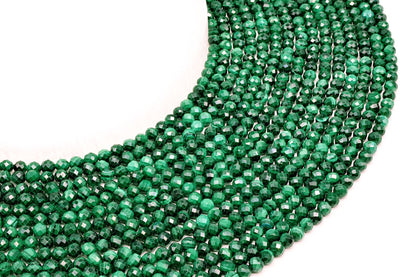Fils de perles facettées en Malachite vert profond disposés en arc sur fond blanc