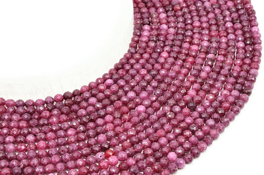 Fils de perles rondes facettées de rubis rose et rouge posés côte à côte