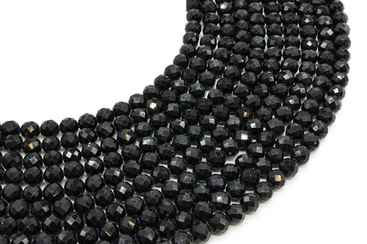Fils de perles rondes facettées en Tourmaline Noire disposés en arc sur fond blanc