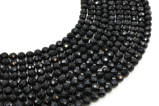 Fils de perles rondes facettées en Tourmaline Noire disposés en arc sur fond blanc