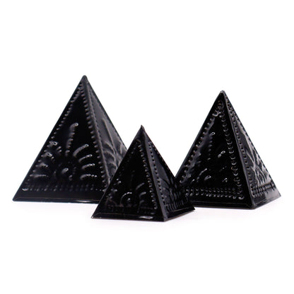 Trois moules pyramidaux en métal noir laqué à motifs solaires repoussés, tailles graduées