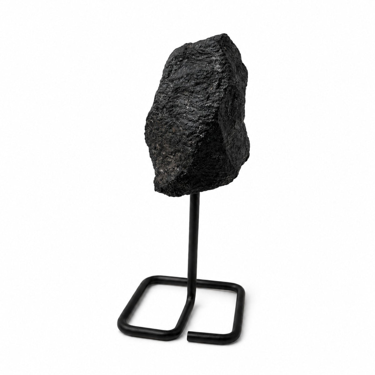 Tourmaline noire brute posée sur un support en métal noir minimaliste
