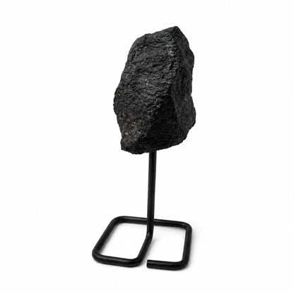 Tourmaline noire brute posée sur un support en métal noir minimaliste