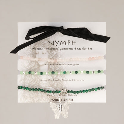 Trois bracelets en quartz rose, malachite et aventurine sur carte illustrée avec ruban noir