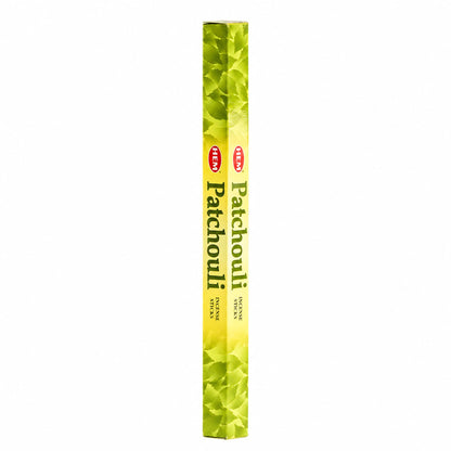 Étui hexagonal vert et jaune d'encens HEM Patchouli en bâtonnets sur fond blanc