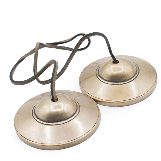 Paire de cymbales tibétaines tingsha en laiton reliées par une lanière en cuir