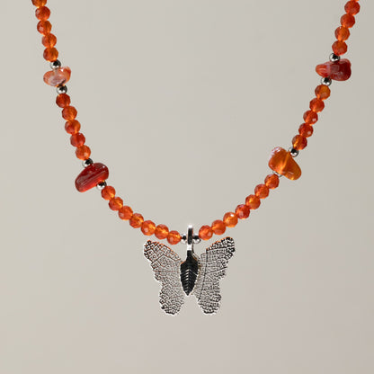 Collier de perles de cornaline orangées avec pendentif papillon en feuille argentée