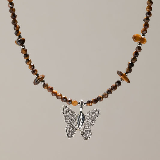 Collier de perles facettées d'Œil de Tigre avec pendentif papillon argenté en feuille
