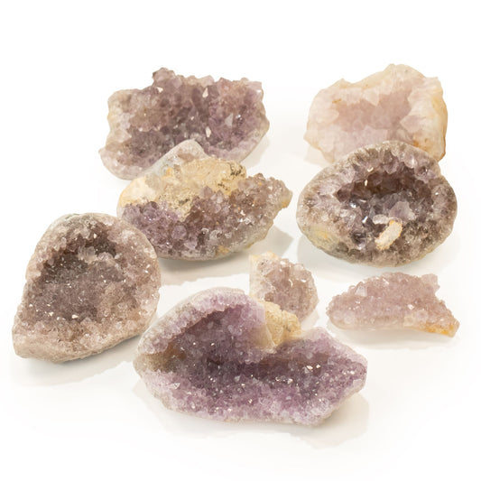 Plusieurs petites géodes d'améthyste ouvertes aux cristaux violets et lilas sur fond blanc