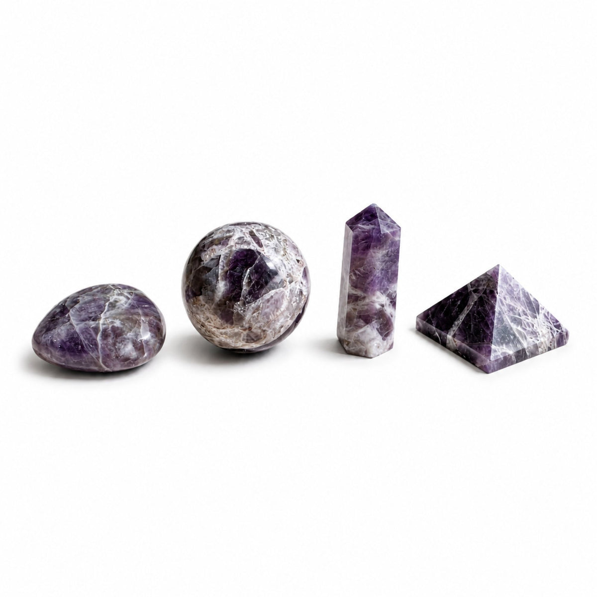 Quatre pierres en améthyste violette : galet, sphère, pointe et pyramide alignés