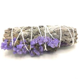 Bâton de sauge lié de fil blanc orné de petites fleurs séchées violettes