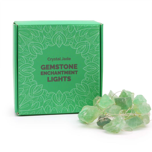 Guirlande lumineuse en fluorite verte brute posée devant sa boîte cadeau verte