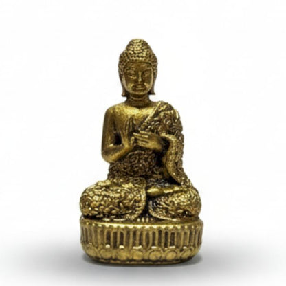 Petite statuette dorée de Bouddha assis en méditation sur un socle lotus